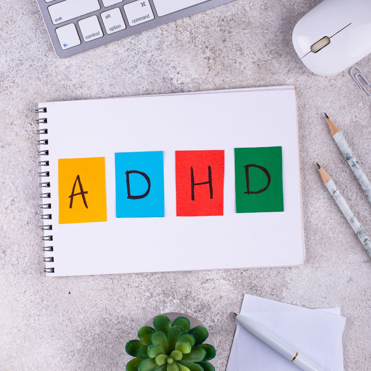 The words ADHD on a notebook on a desk.