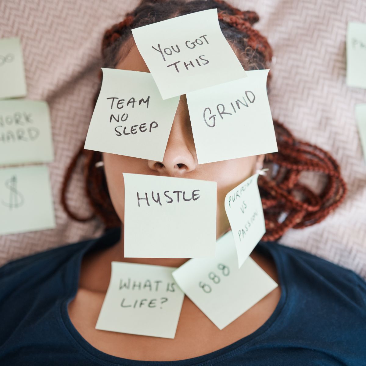 A woman overwhelmed by too many tasks with post it notes with things to do written on each note.