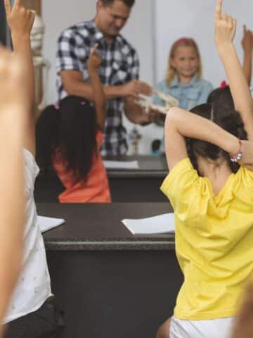 An image of kids in a school classroom raising their hands and the text "help your child thrive at school."