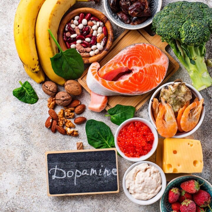 An overhead shot of fish, bananas, nuts, and other healthy foods that increase dopamine natrually with the text "how to increase dopamine."