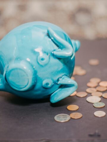 A piggy bank knocked over with coins coming out.